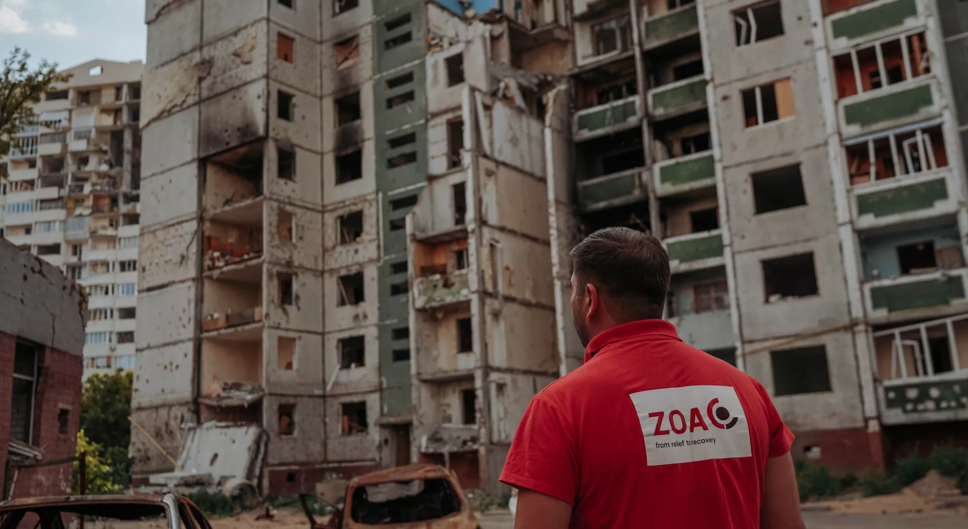 ZOA medewerker kijkt naar kapotte gebouwen