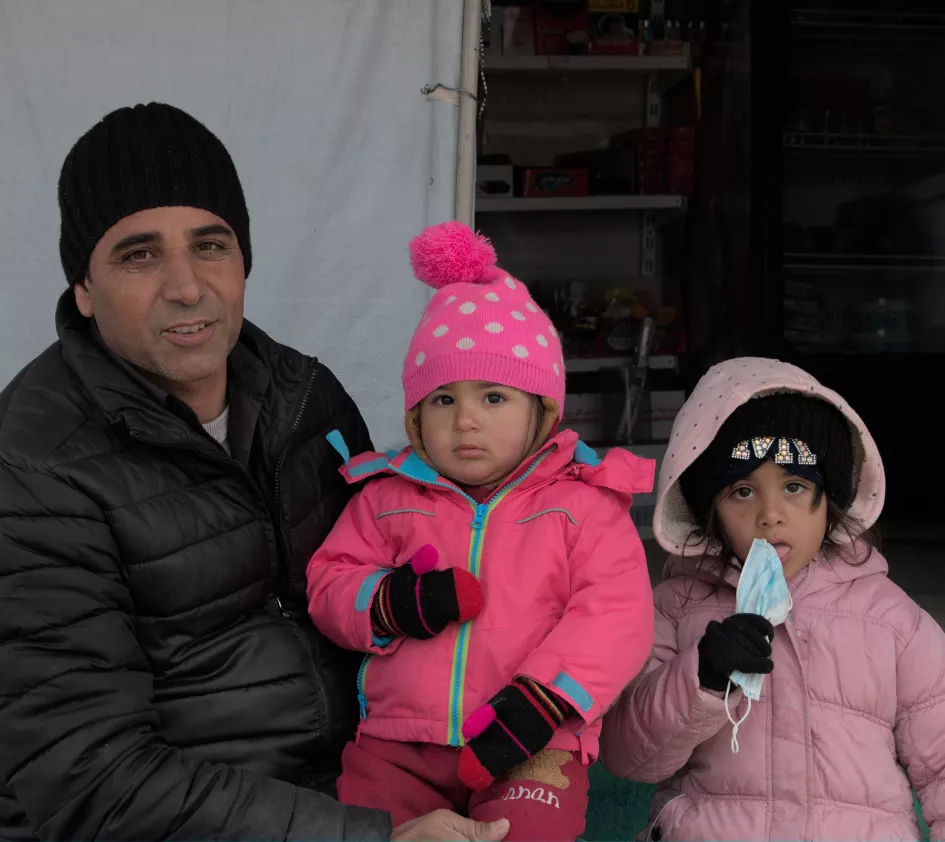 Een vader met zijn kinderen in een vluchtelingenkamp in Irak