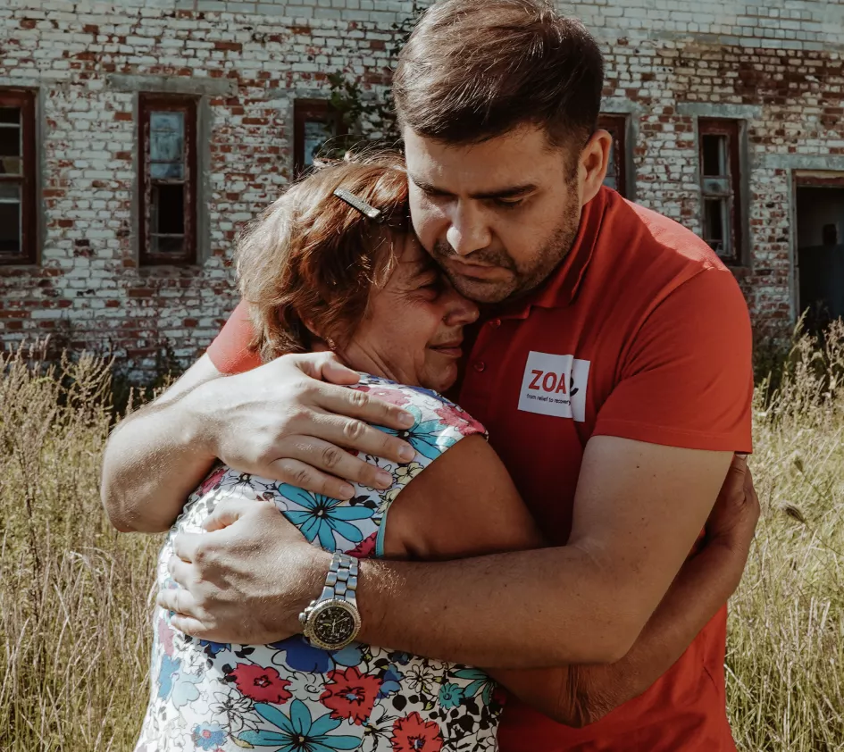 Een ZOA-medewerker omarmt een getroffen vrouw in Oekraïne