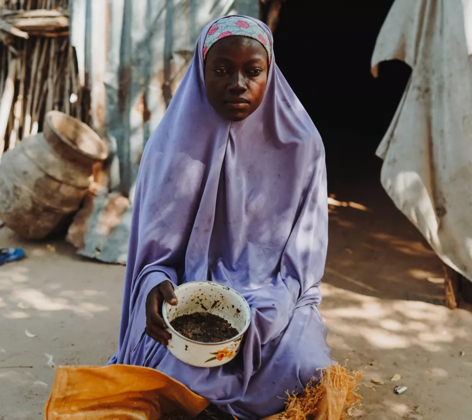 Habiba laat zien wat ze nog aan eten heeft voor de aankomende dagen met haar vier kinderen. In het pannetje zit een handjevol gestampt graan.