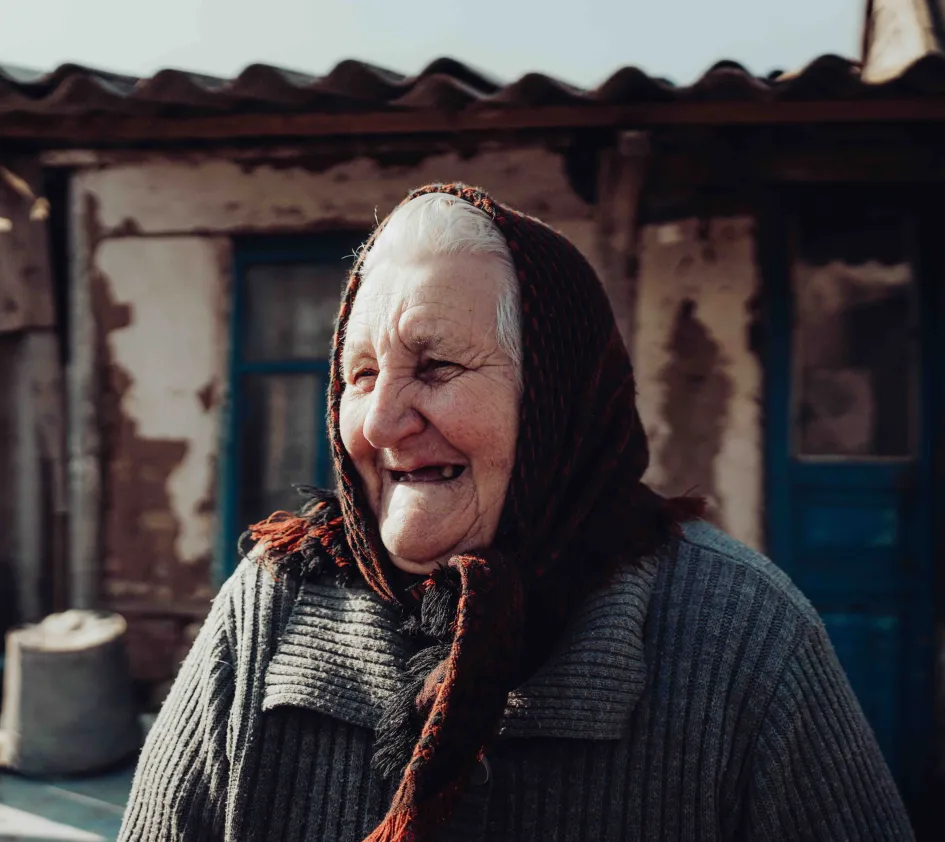 Larisa lachend voor haar huis