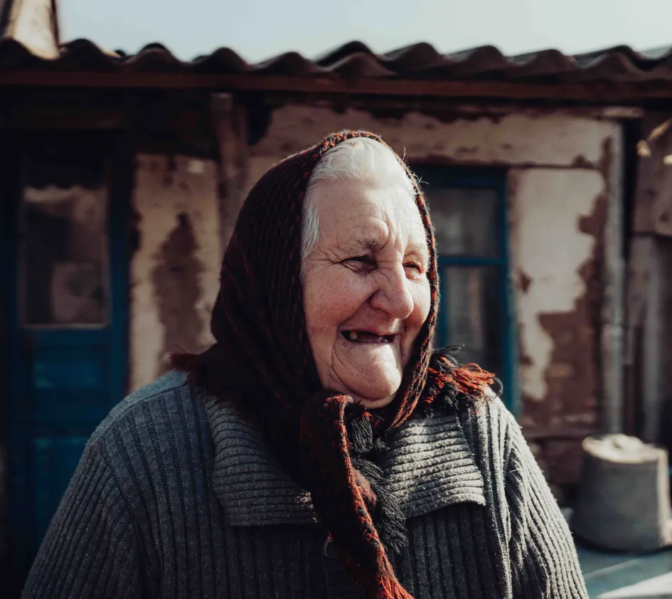 Larisa lachend voor haar huis