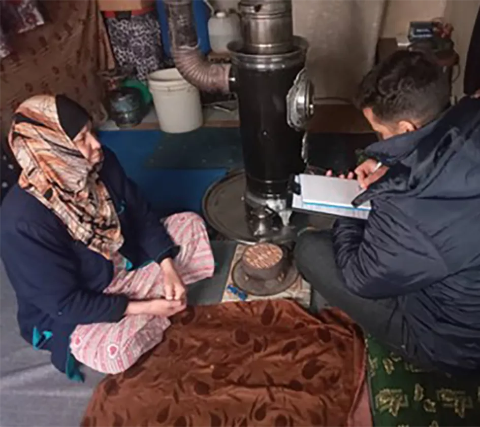 Safeea sitting on the ground with ZOA employee