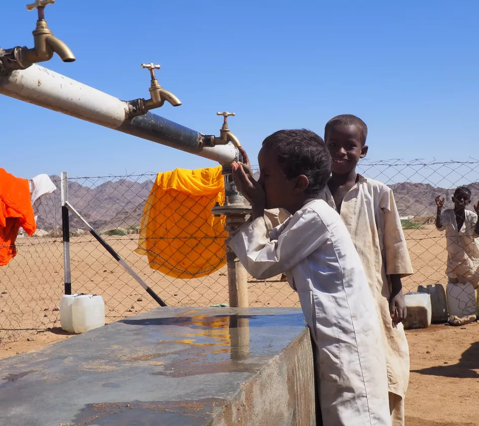 Boys in Sudan drink water