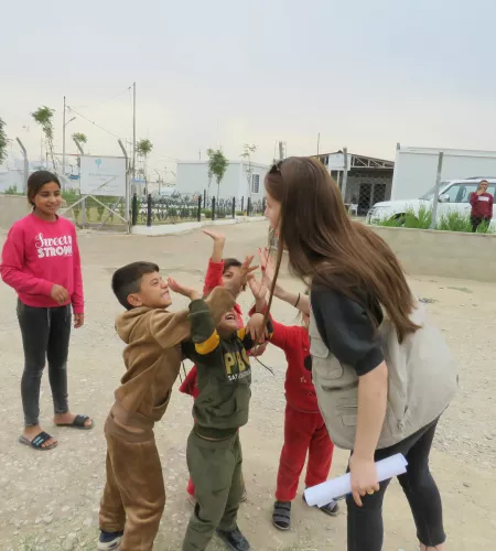 ZOA medewerker geeft kinderen in Bardarash, Irak een high five