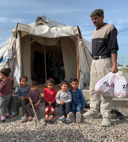Mensen bij een tent in een vluchtelingenkamp