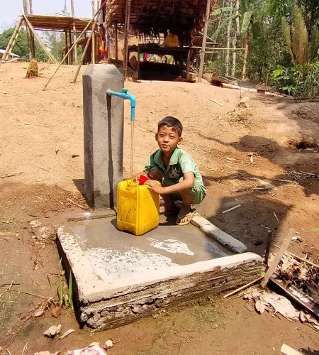 Kind bij waterpomp in Myanmar