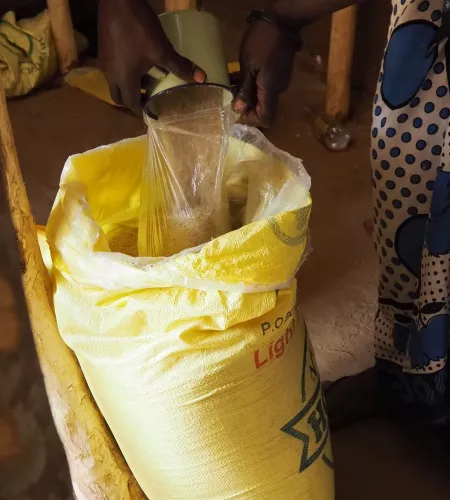 Graan wordt uit een zak geschept in Uganda