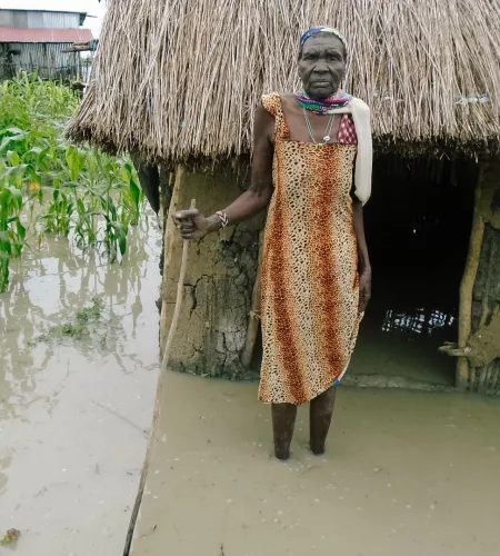 Een vrouw bij haar overstroomde huis