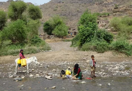 Wat is er aan de hand in Jemen: vrouw wast kleren bij de rivier