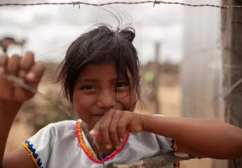 Lijst van vergeten: Colombiaans meisje staat bij een hek met gaas