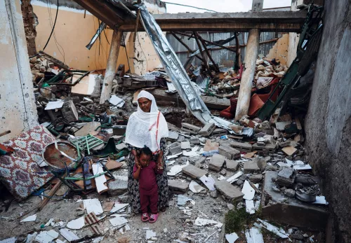 Adhanet Berhe bij hun verwoeste huis