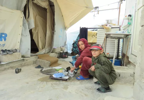 Vrouw met kinderen bij een oude tent in Bardarash