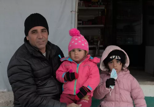 Een vader met zijn kinderen in een vluchtelingenkamp in Irak