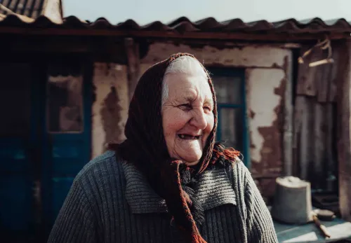 Larisa lachend voor haar huis